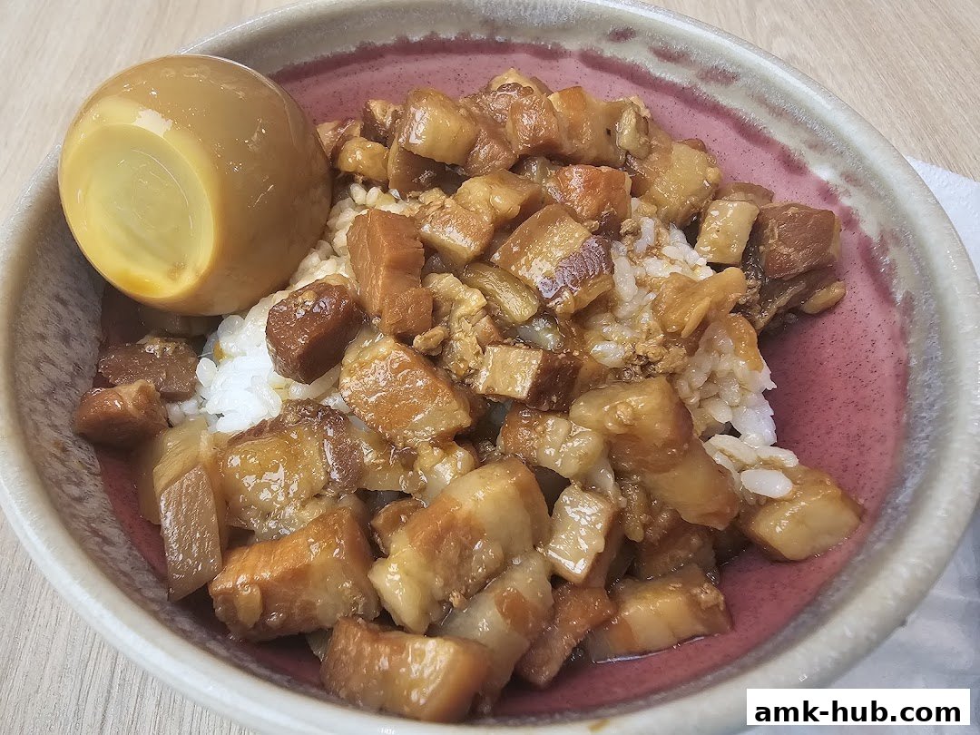 A close-up of a bowl of braised pork rice with a braised egg.