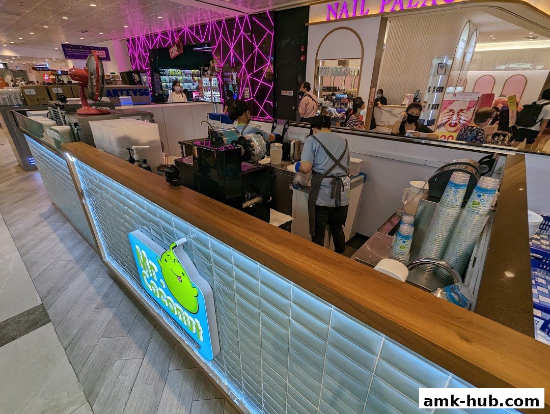 A Mr. Coconut stall with staff preparing drinks and customers in the background.