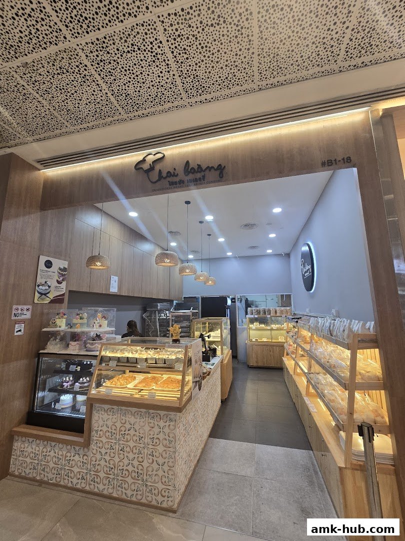 Interior view of a bakery shop with display cases filled with bread and cakes.