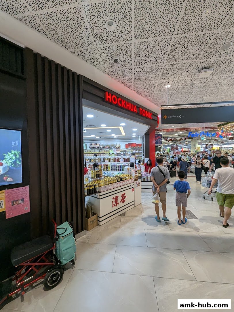 The Hockhua Tonic shop entrance with products displayed and people walking by.