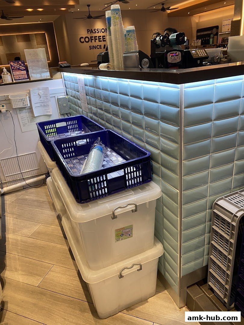 A counter area with stacked storage bins and cups, suggesting a food or beverage establishment.