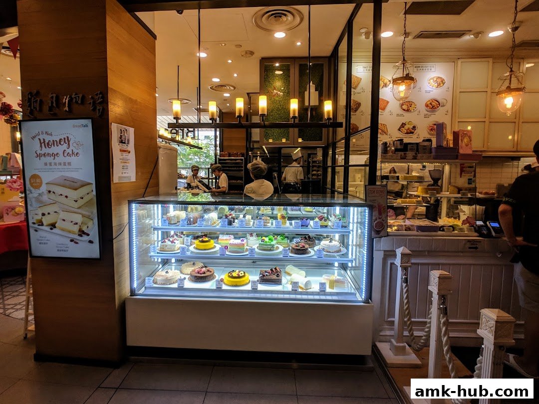 A display case filled with various cakes and pastries at Toast Box AMK Hub.