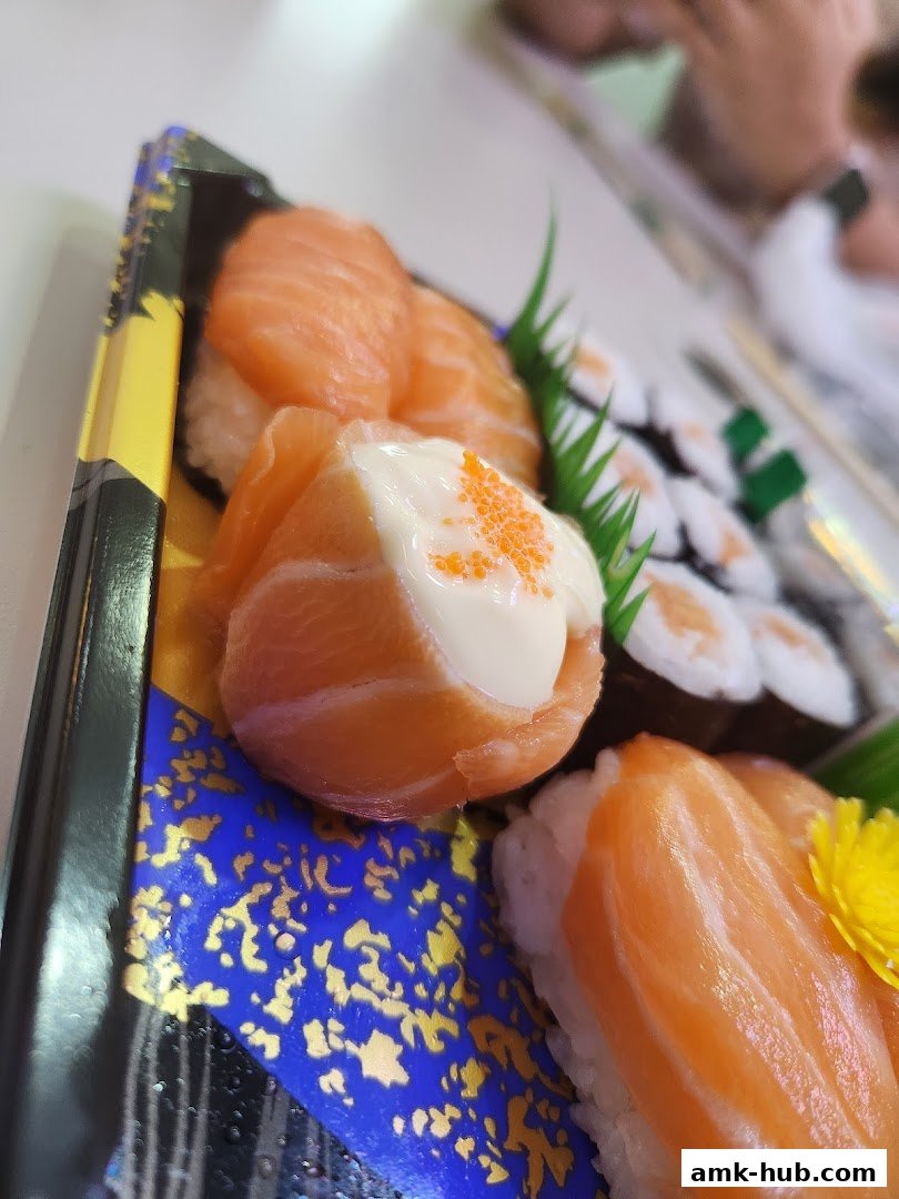 A close-up of a sushi platter featuring salmon nigiri and maki rolls.
