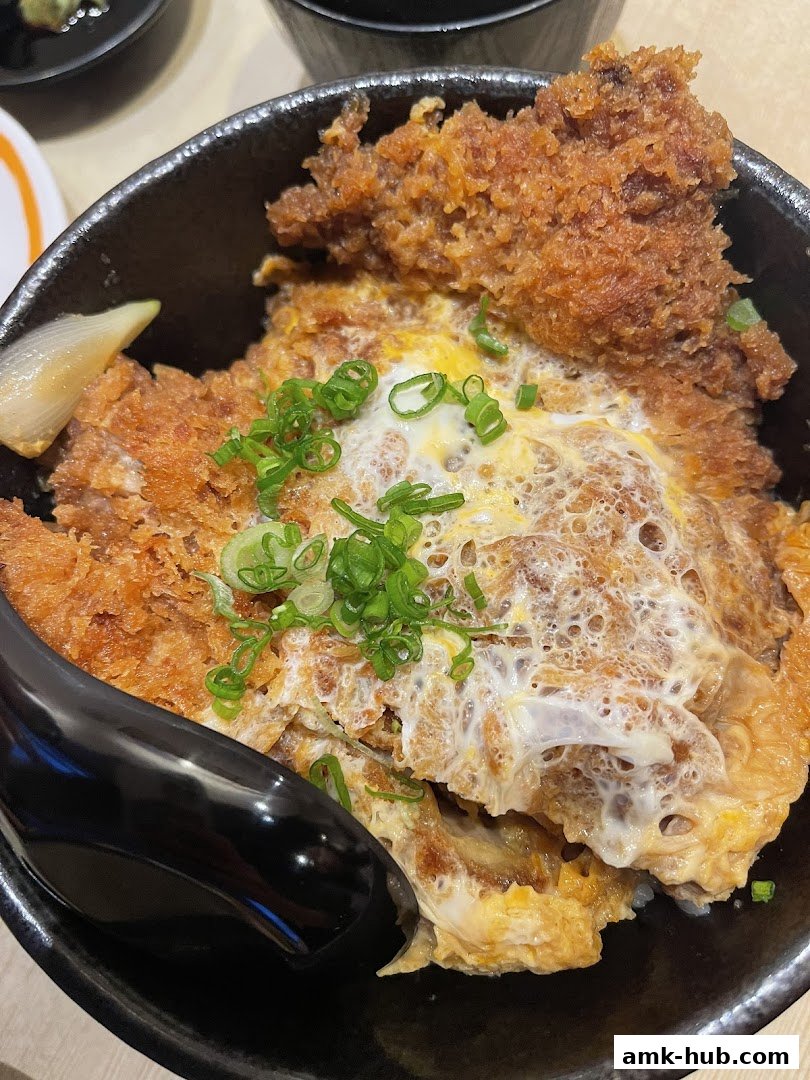 A close-up of a delicious katsudon dish with crispy pork cutlet and egg over rice.