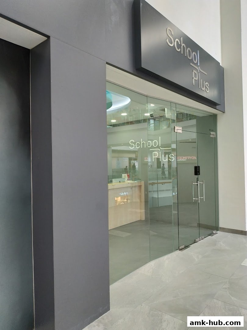 The modern glass entrance of the School Plus shop with its prominent signage.