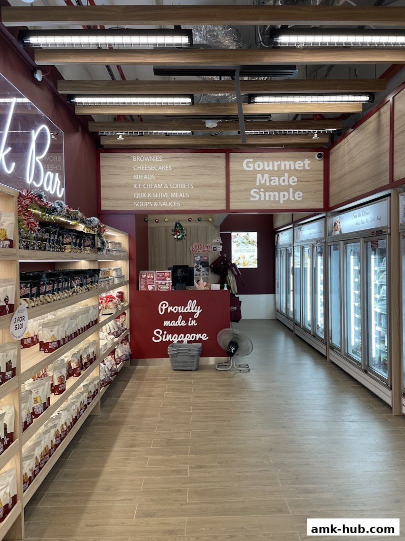 Interior view of a food shop with shelves of products and refrigerated display cases.