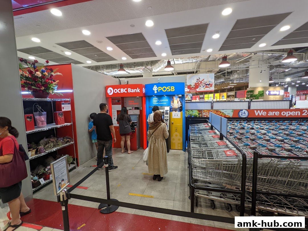 People using OCBC and POSB ATMs inside a Fairprice Xtra supermarket.