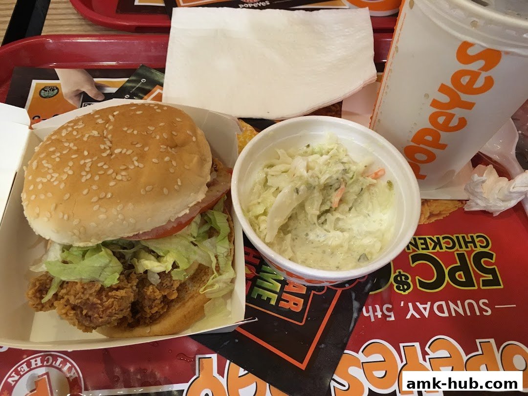 A Popeyes chicken sandwich meal with coleslaw and a drink.