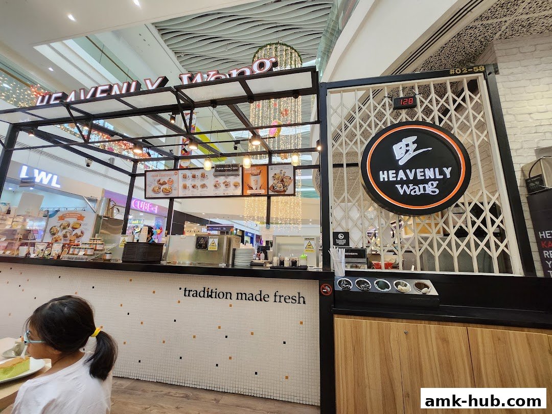 A Heavenly Wang food stall with a menu displayed and a customer seated.