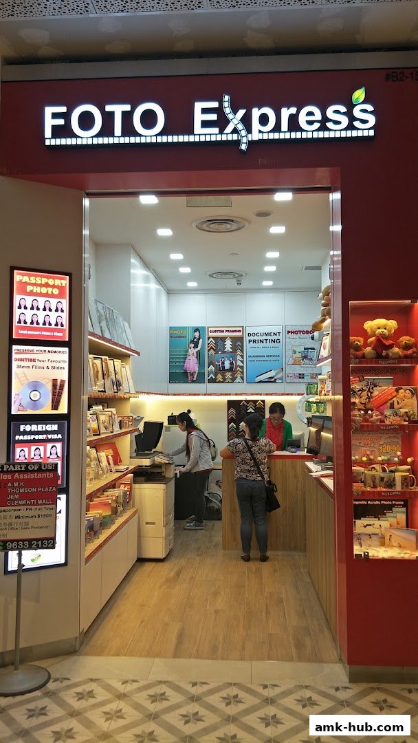 The entrance of Foto Express, a photo printing and framing shop, with staff and customers inside.