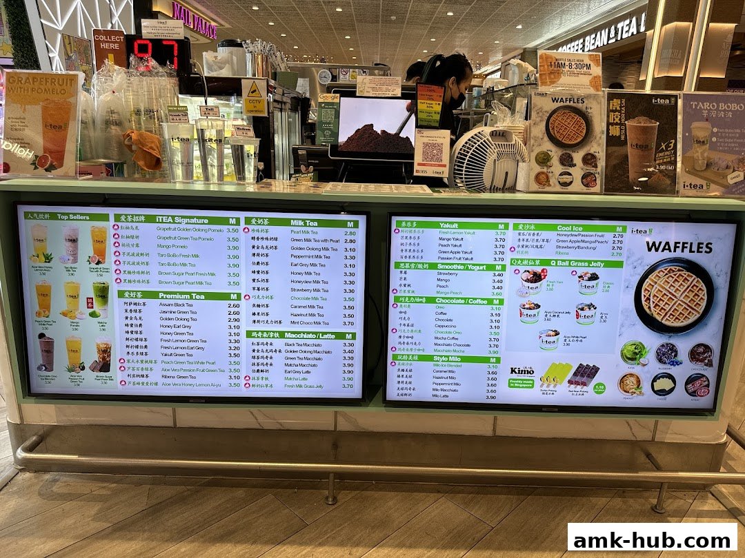 A digital menu board displaying various iTEA drinks and waffles with prices.