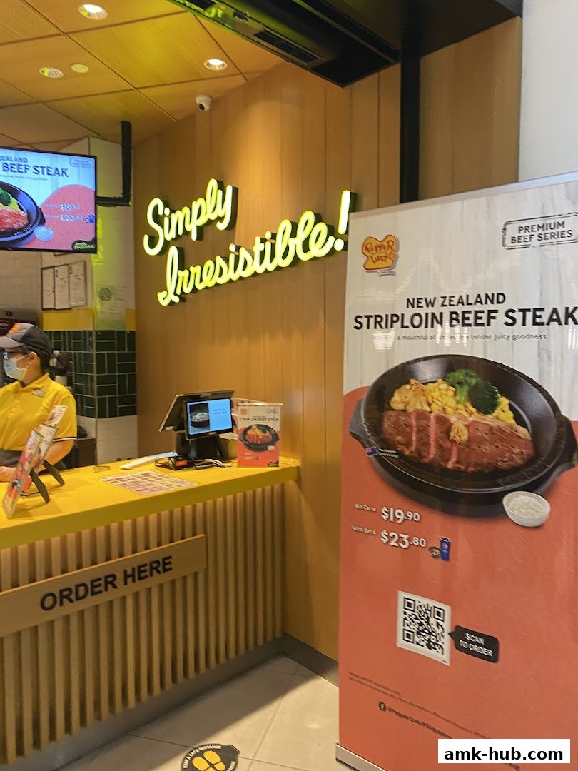A Pepper Lunch counter with a "Simply Irresistible!" sign and a promotional banner for New Zealand Striploin Beef Steak.