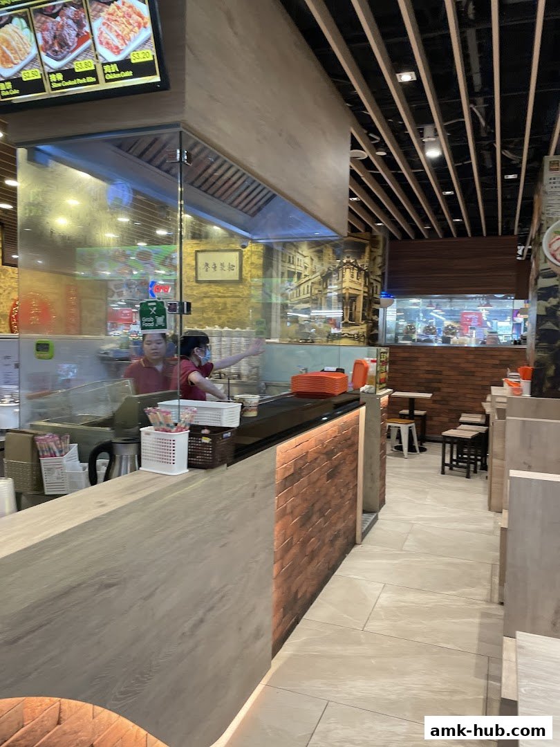 Interior view of Pontian Wanton Noodle shop with staff preparing food behind a counter.