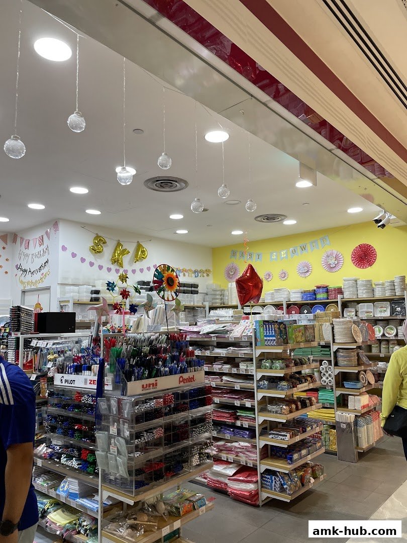 Interior view of a retail store with shelves stocked with stationery, party supplies, and home goods.