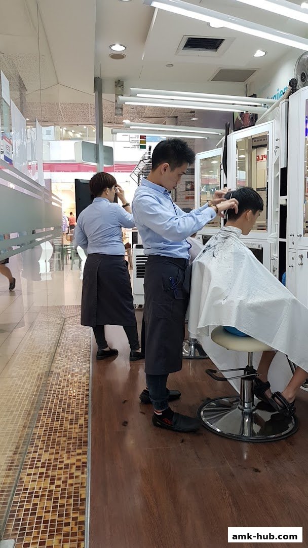 Barbers are cutting hair for customers inside a clean, well-lit salon.