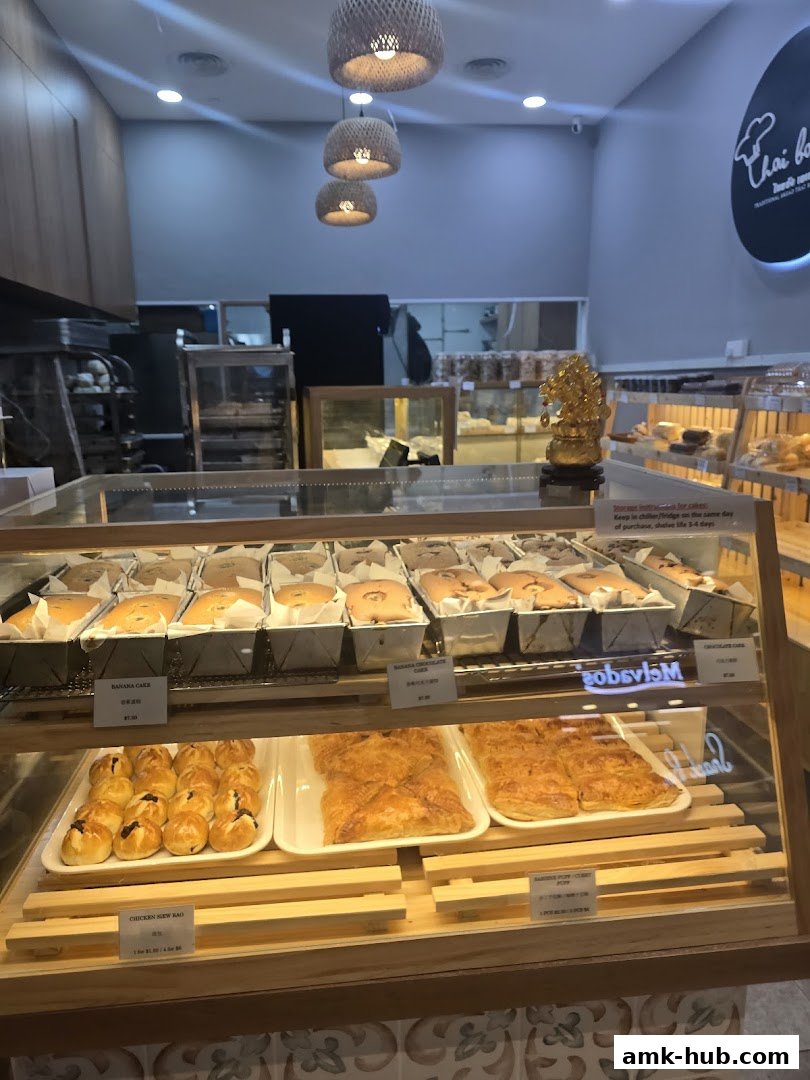 Interior view of a bakery with display cases filled with bread and cakes.