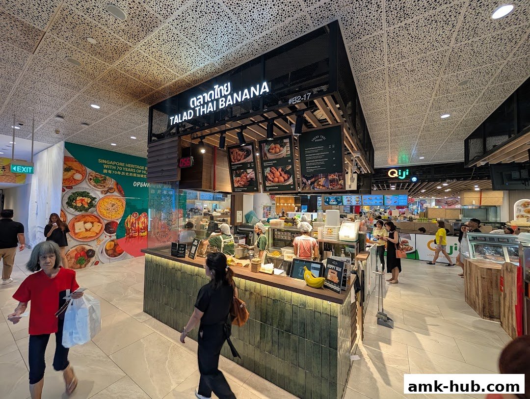 A busy food stall named Talad Thai Banana with customers ordering and staff preparing food.