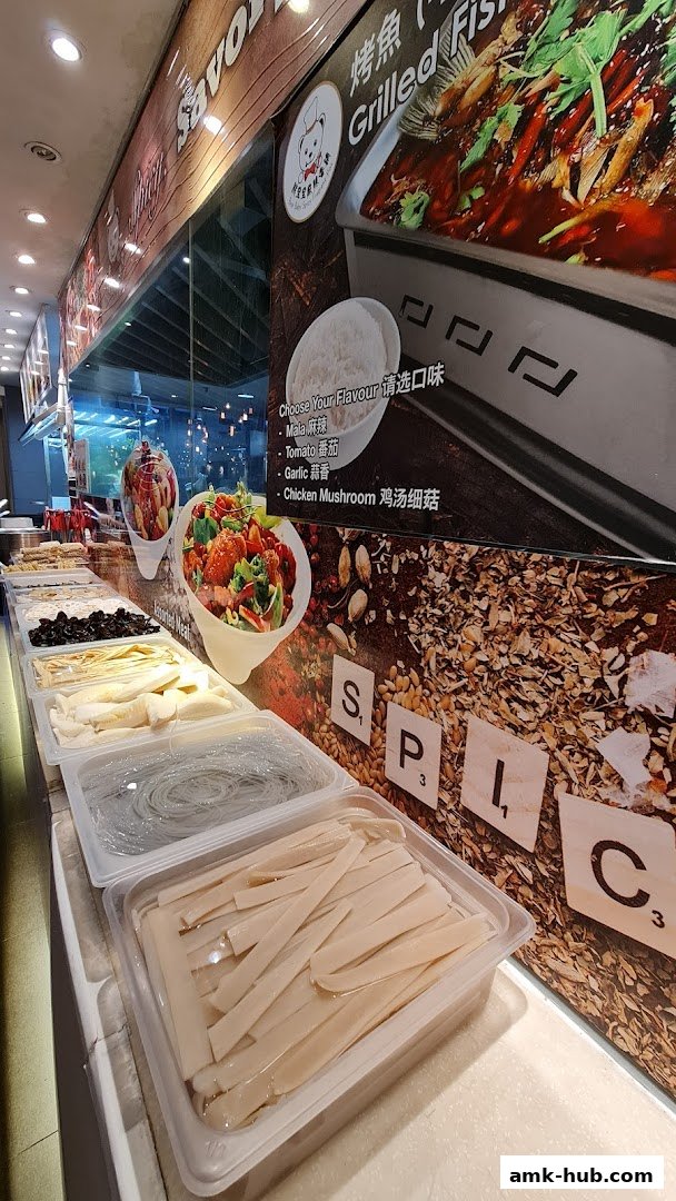A display of fresh ingredients and a menu board for grilled fish at Kopitiam.