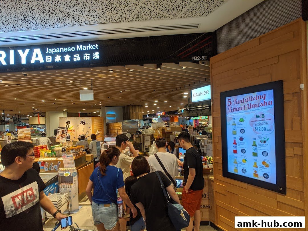 Customers browse products at Kuriya Japanese Market, with a promotional display for Umeshu.