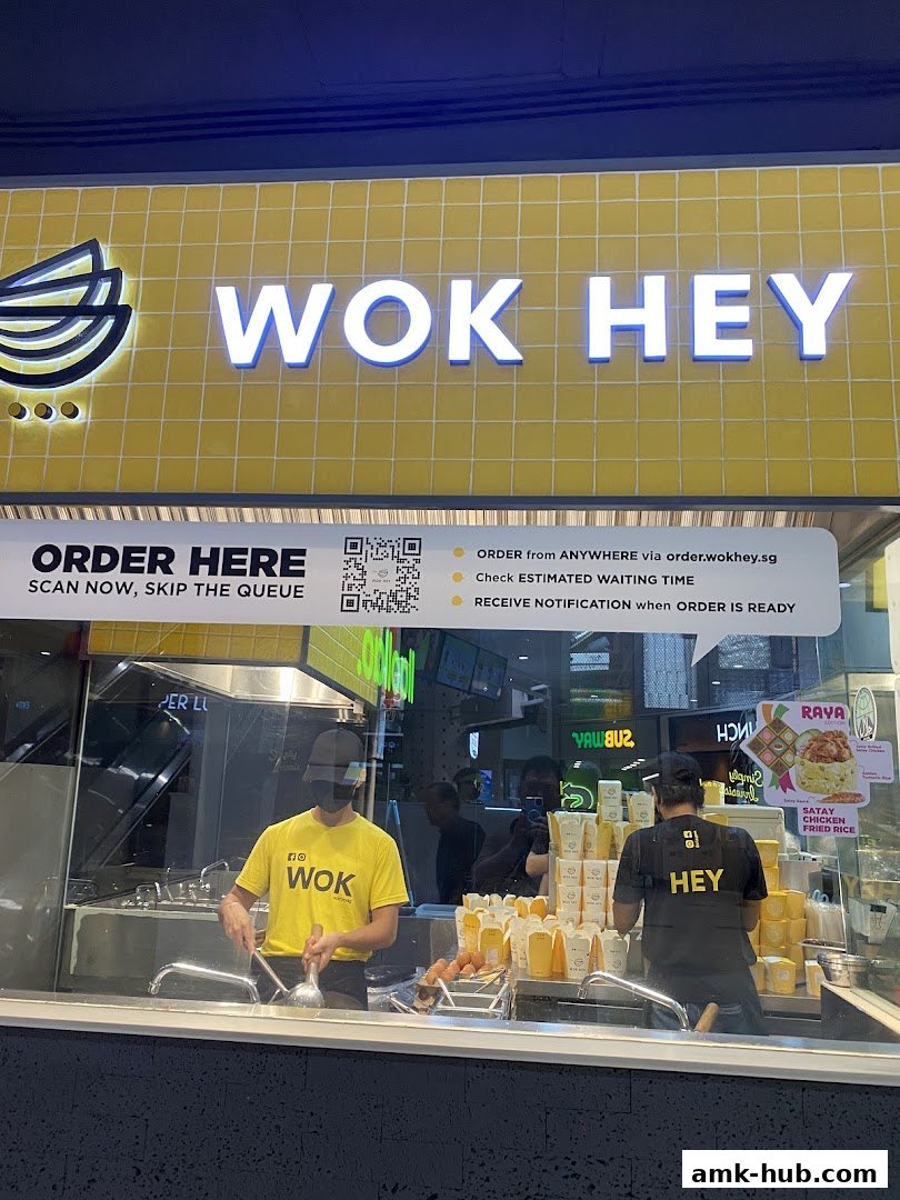 Wok Hey shop with staff preparing food and ordering instructions displayed.