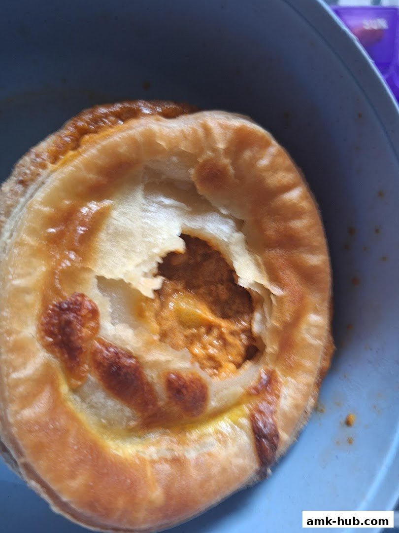 A close-up shot of a golden-brown savory pie with a flaky crust and a rich filling.