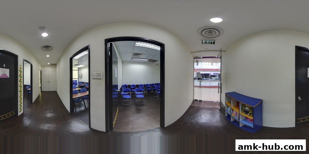 Interior view of a hallway with classrooms and an exit sign.