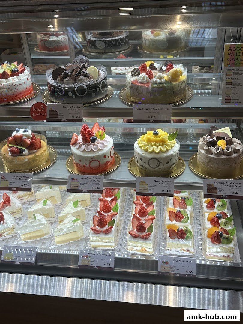 A display case filled with various beautifully decorated cakes and cake slices.