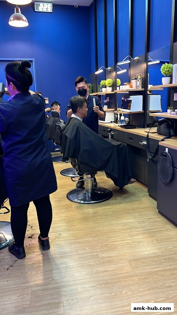 Barbers are cutting hair for customers in a modern, blue-themed barbershop.