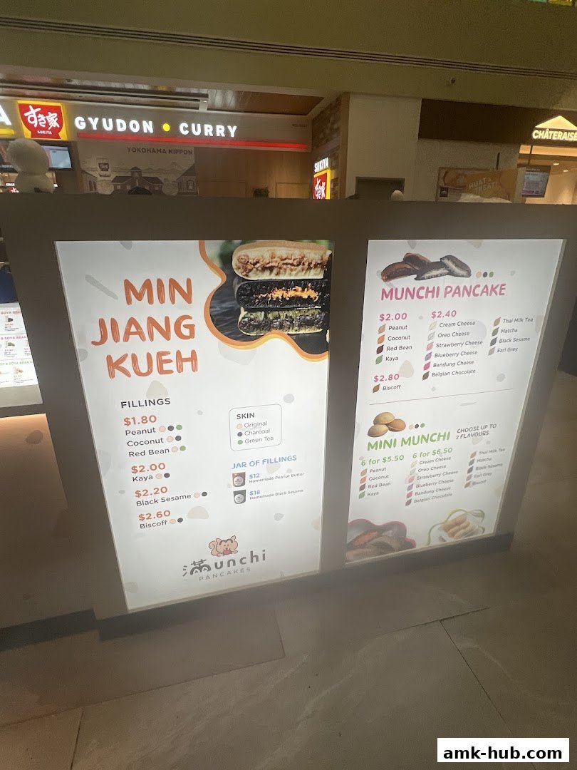 A brightly lit menu board for Munchi Pancakes, showcasing various fillings and pancake options.