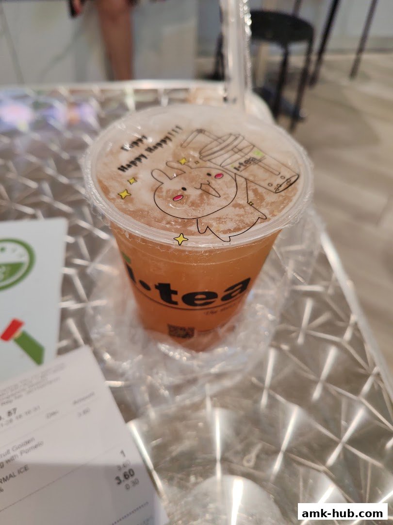 A cup of iTEA bubble tea with a cute bunny design on the lid, placed on a metallic table.
