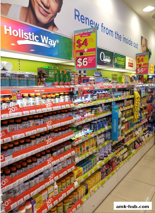 A brightly lit aisle in a Watsons store showcasing health supplements and promotional signage.