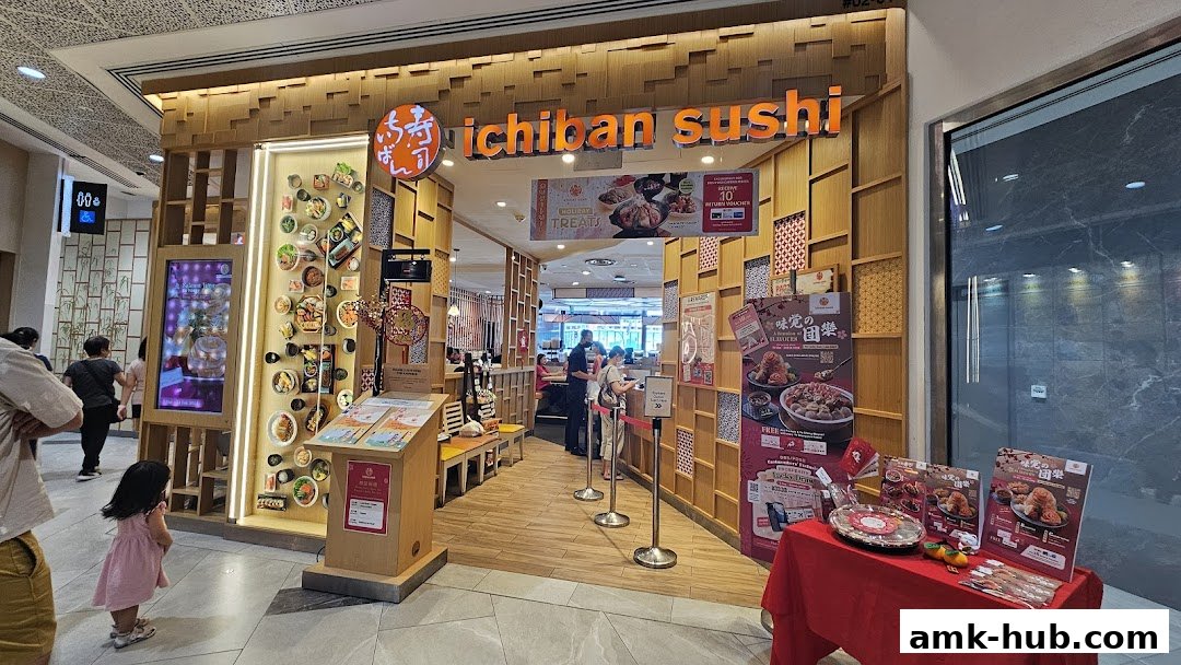 The entrance of Ichiban Sushi Ang Mo Kio, featuring a warm wooden facade and promotional displays.