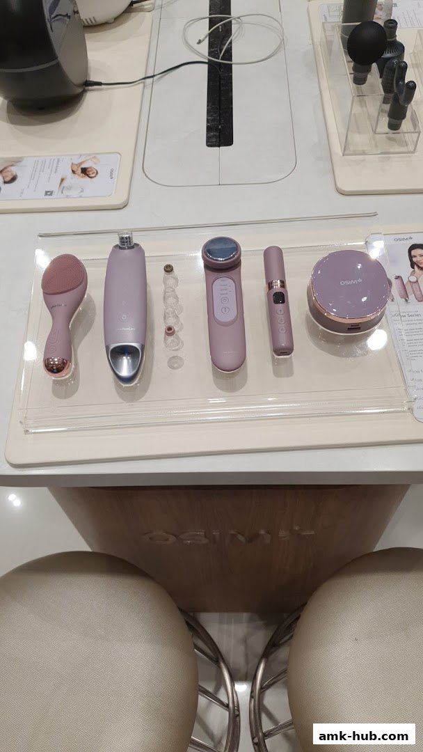 OSIM beauty devices displayed on a white counter with chairs in the foreground.