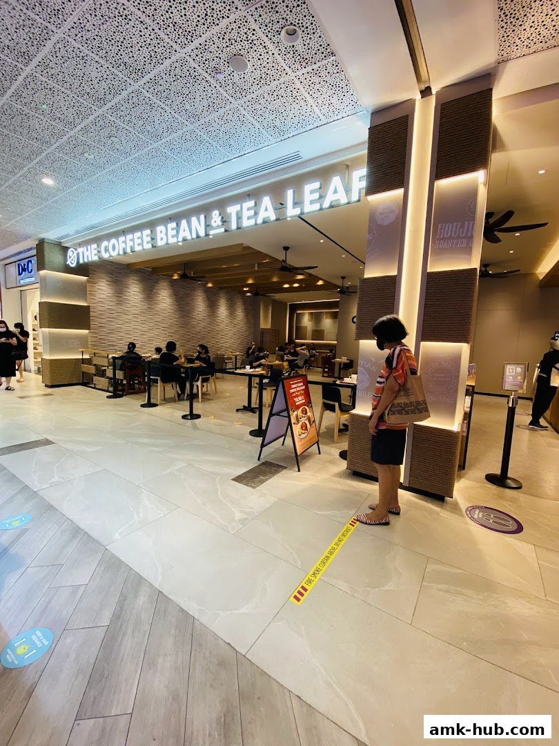 The Coffee Bean & Tea Leaf shop entrance with customers inside and a person standing outside.