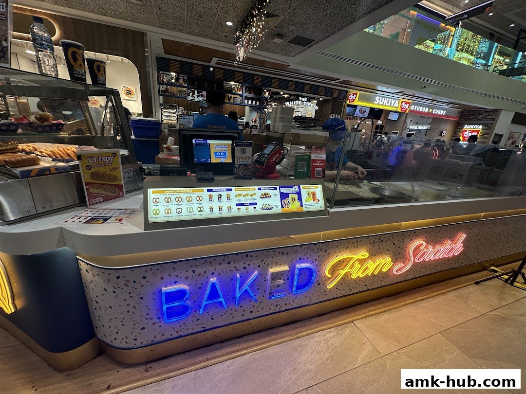 Auntie Anne's pretzel shop counter with a display of pretzels and a neon sign.