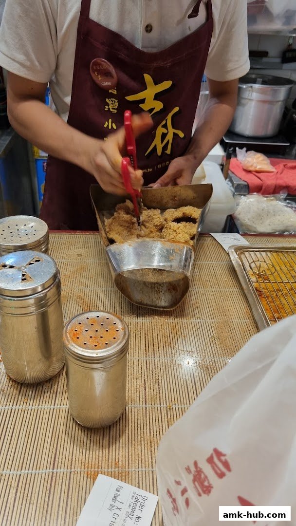 A staff member is preparing Taiwanese fried chicken with scissors.