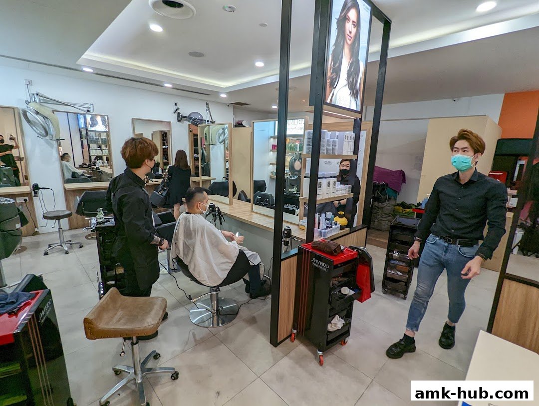 Hair stylists attend to clients in a modern salon with mirrors and product displays.