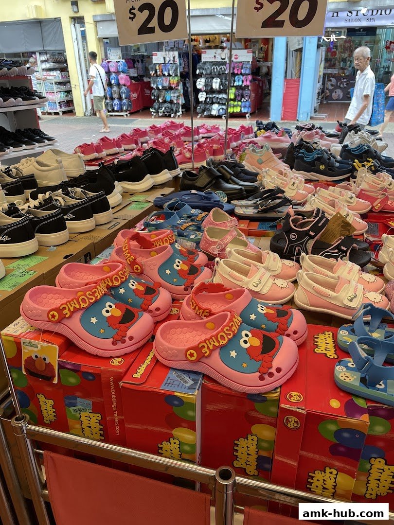 A display of various children's shoes, including sandals and sneakers, with price tags visible.