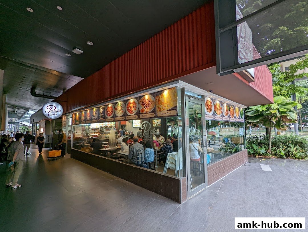 The exterior of Prata Raya restaurant with customers dining inside and food displayed.