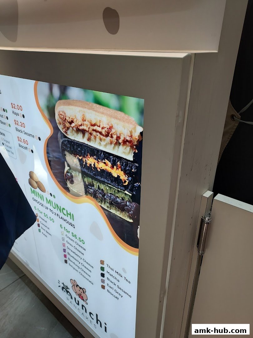 A menu board for Munchi Pancakes featuring various flavors and prices.