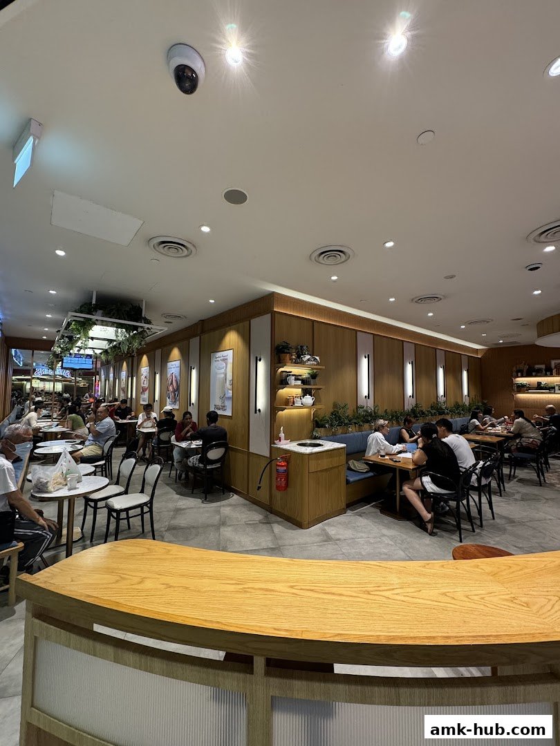 Interior view of a busy Paris Baguette cafe with customers dining at tables.
