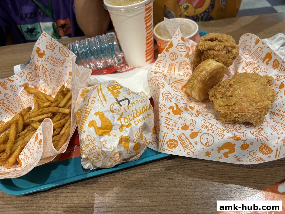 A tray of Popeyes fried chicken, fries, a biscuit, and drinks.