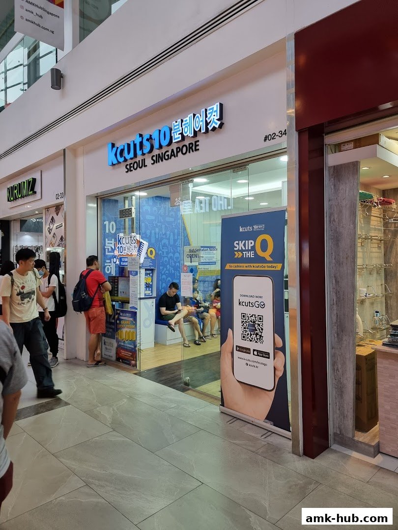 The exterior of a kcuts hair salon with customers inside and a promotional banner.