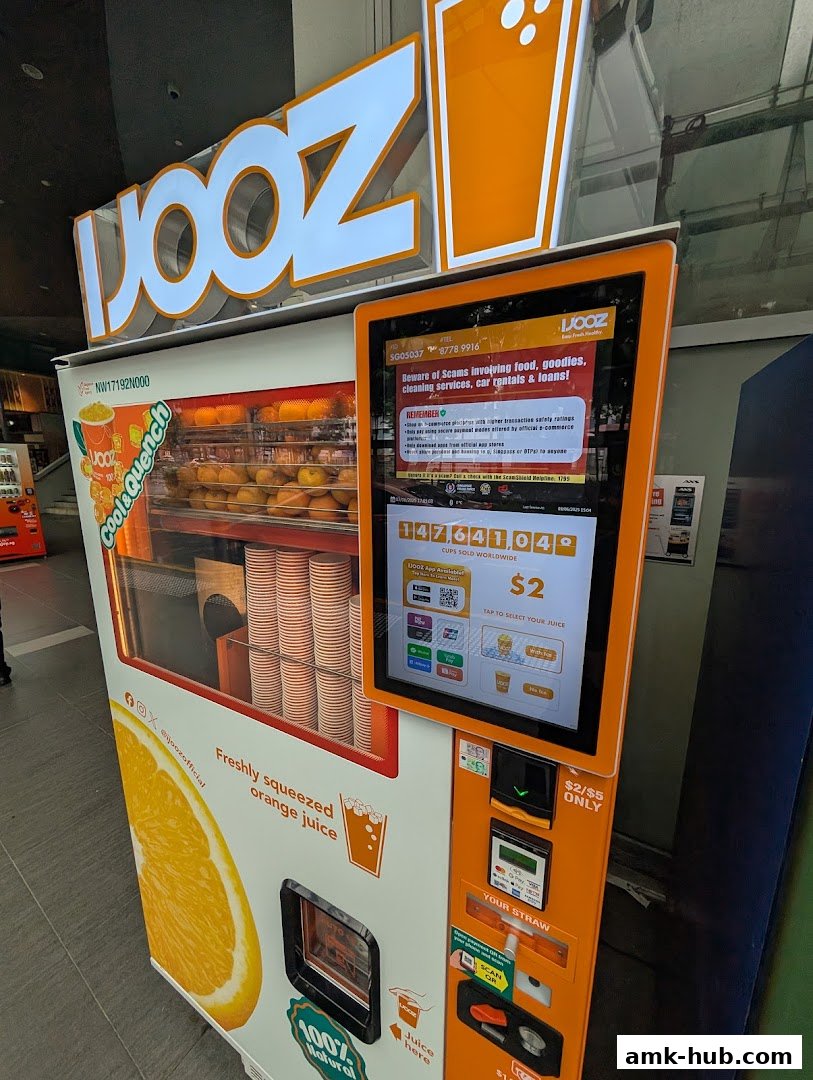 A self-service juice vending machine offering freshly squeezed orange juice.