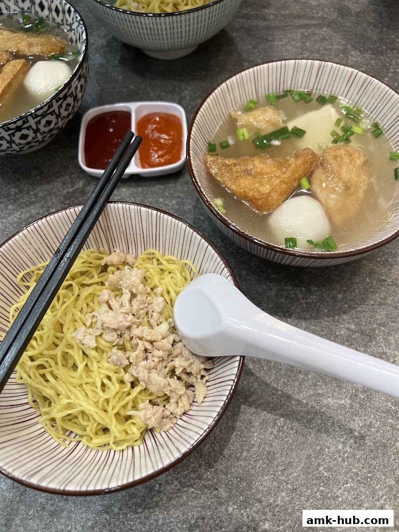 Bowls of delicious noodles with soup, fish balls, and fried tofu, served with chili sauce.