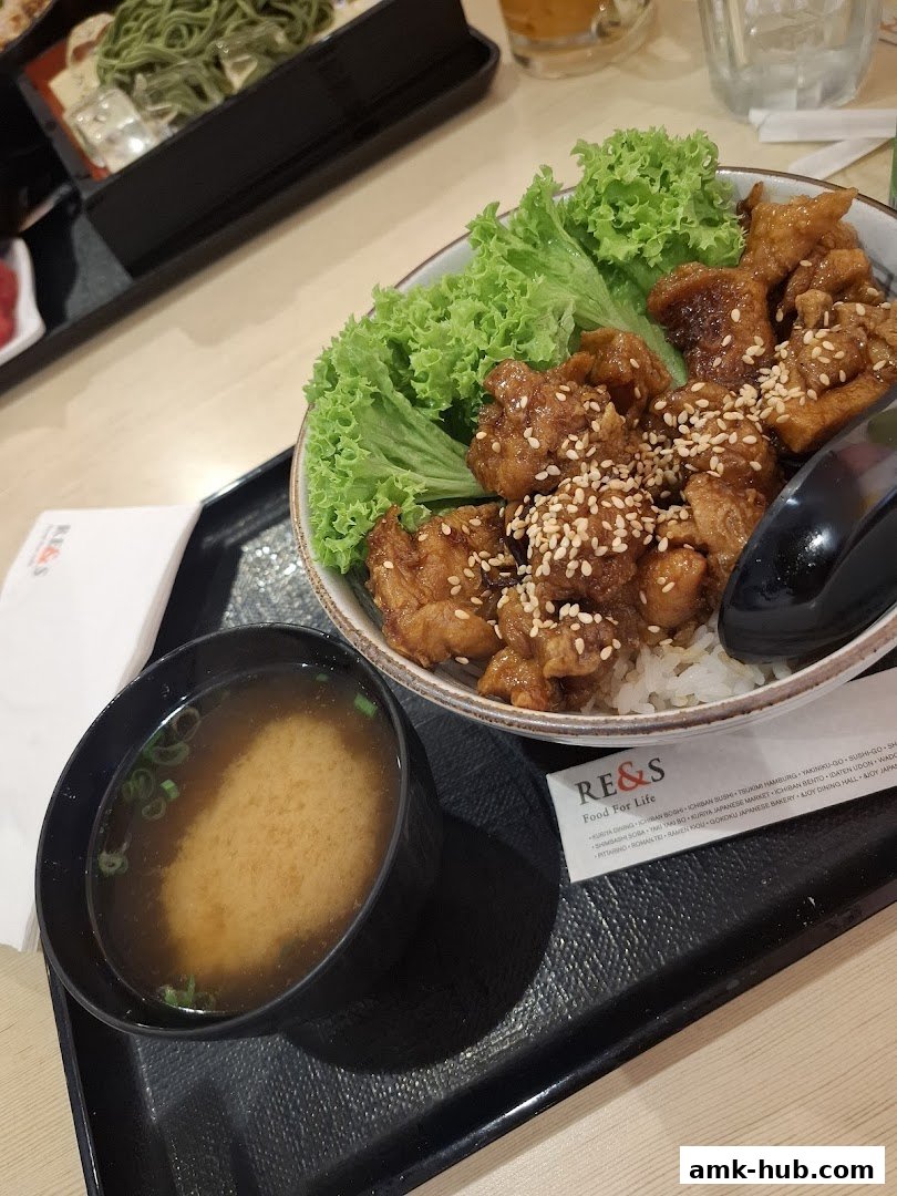 A delicious Japanese rice bowl with fried chicken and a side of miso soup.