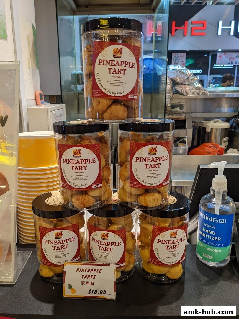 Jars of pineapple tarts are displayed on shelves, with a price tag in the foreground.