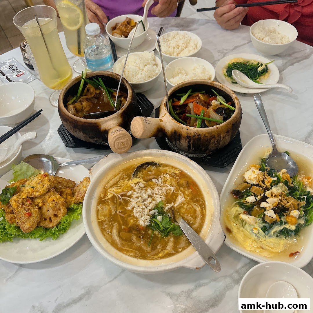 A table laden with various Chinese dishes, including claypot meals, soup, and stir-fried vegetables.