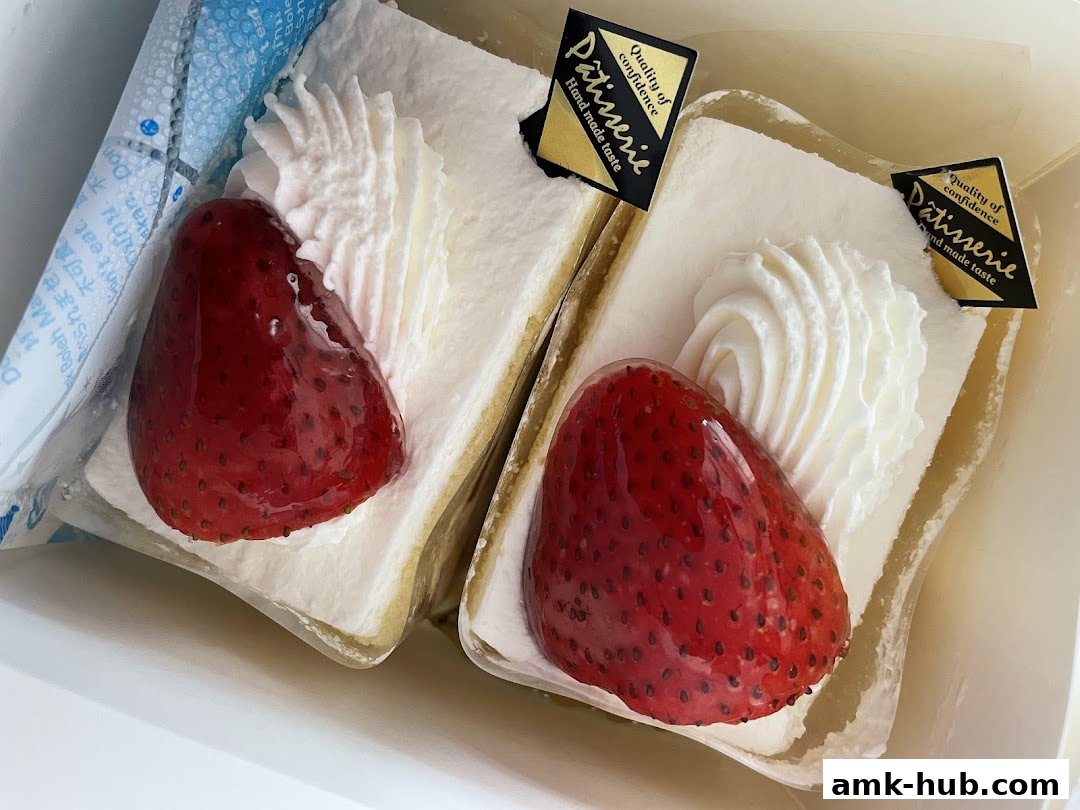 Two slices of strawberry shortcake with whipped cream and a glossy strawberry topping.