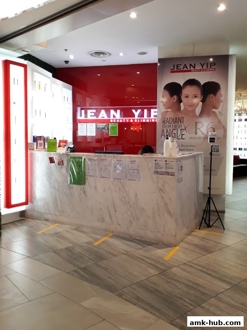 The reception counter of Jean Yip Beauty & Slimming with promotional posters.